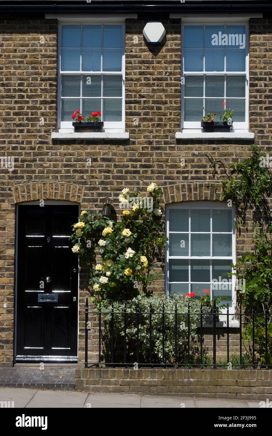 Ein zweistöckiges Häuschen mit Blumen in Fensterkästen und