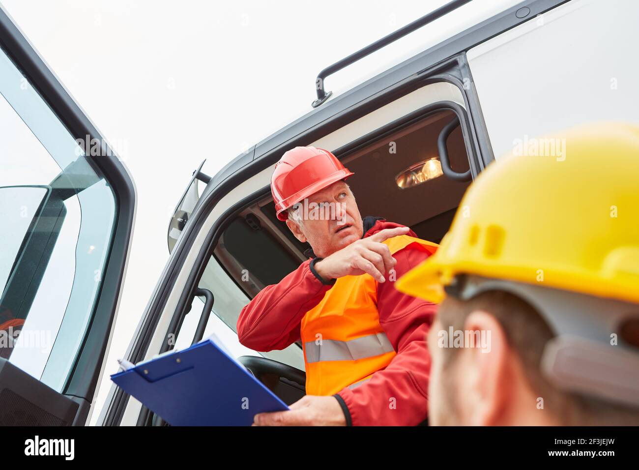LKW-Fahrer vom Spediteur und Bauarbeiter auf Die Baustelle der Straße Stockfoto