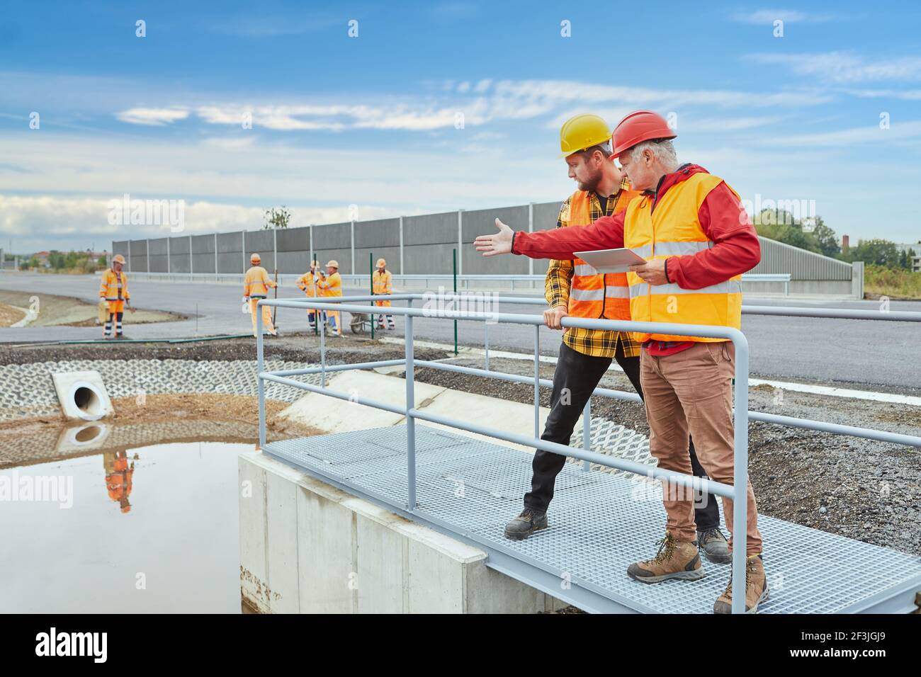 Der Bauleiter kontrolliert die Baustelle beim Bau eines nächsten Hauses Unterwegs mit Tablet-Computer Stockfoto