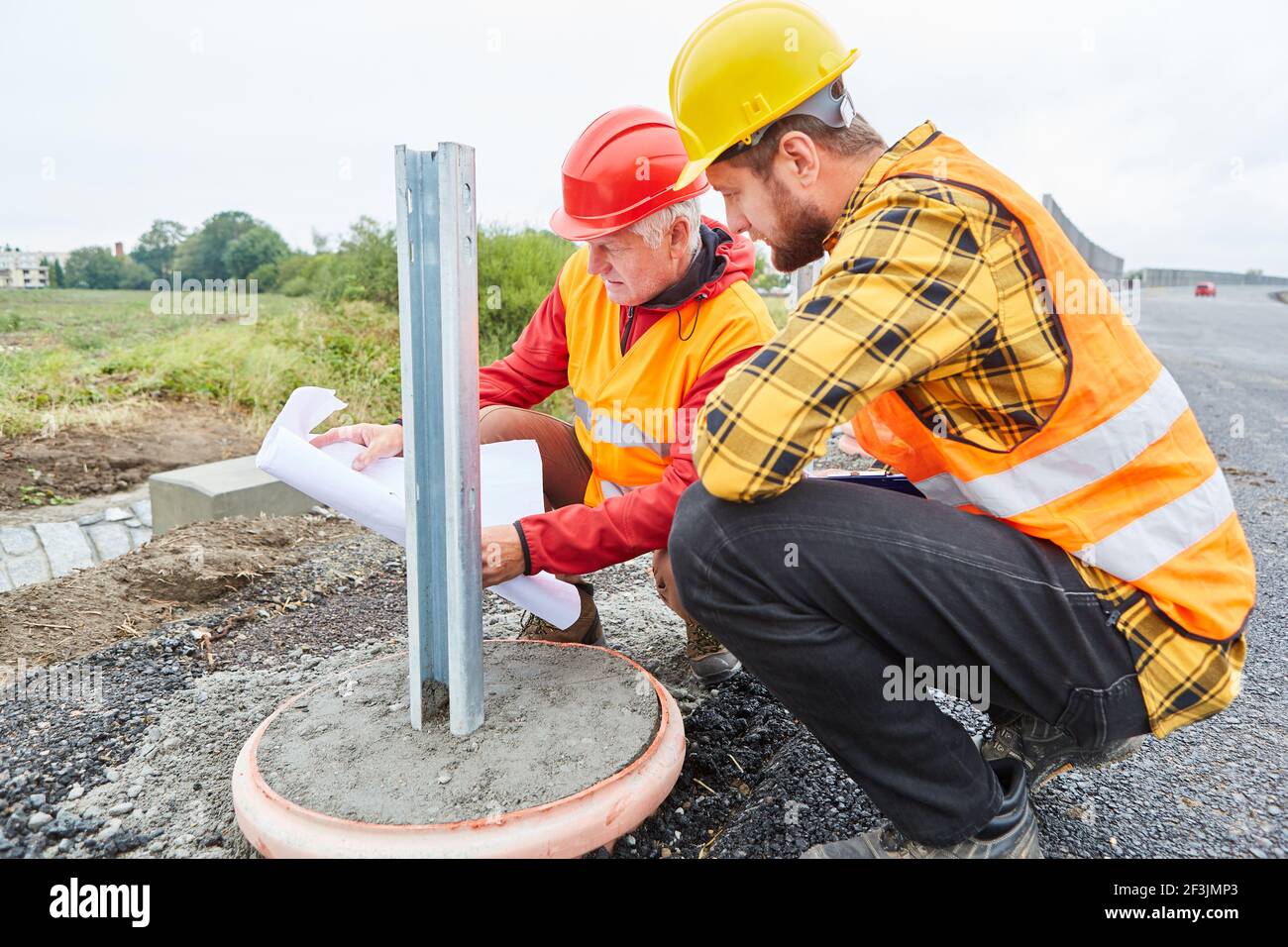 Zwei Bauarbeiter auf der Baustelle für den Hausbau oder Straßenbau neben dem Fundament Stockfoto