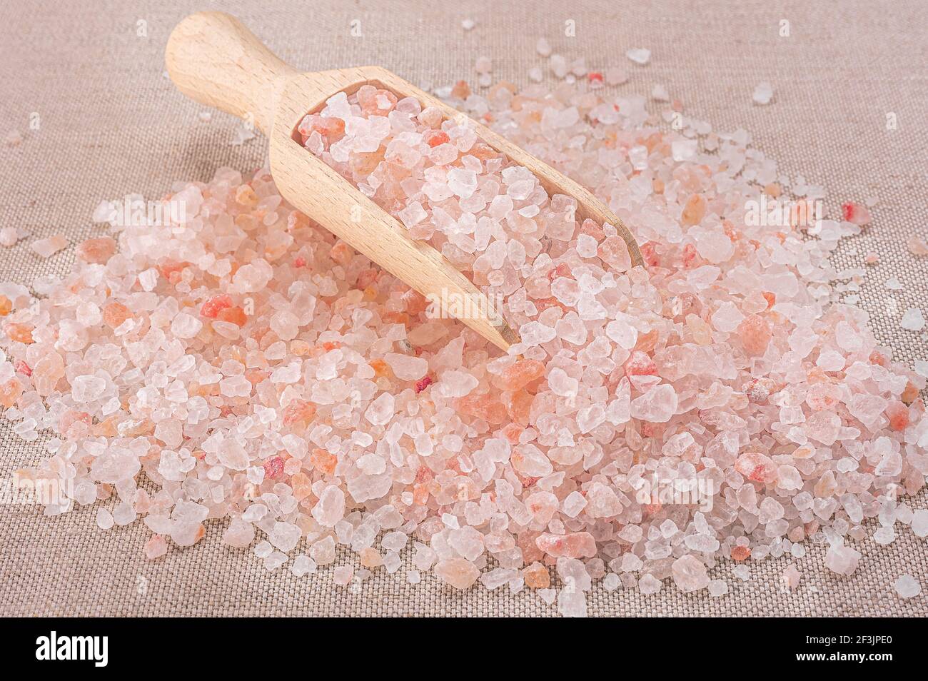 Rosa himalaya-Salz. Nahaufnahme Himalayan Pink Rock Salt in Holzlöffel auf schwarzem Hintergrund. Draufsicht. High Angle View Of Himalayan Salt With Wooden Sp Stockfoto