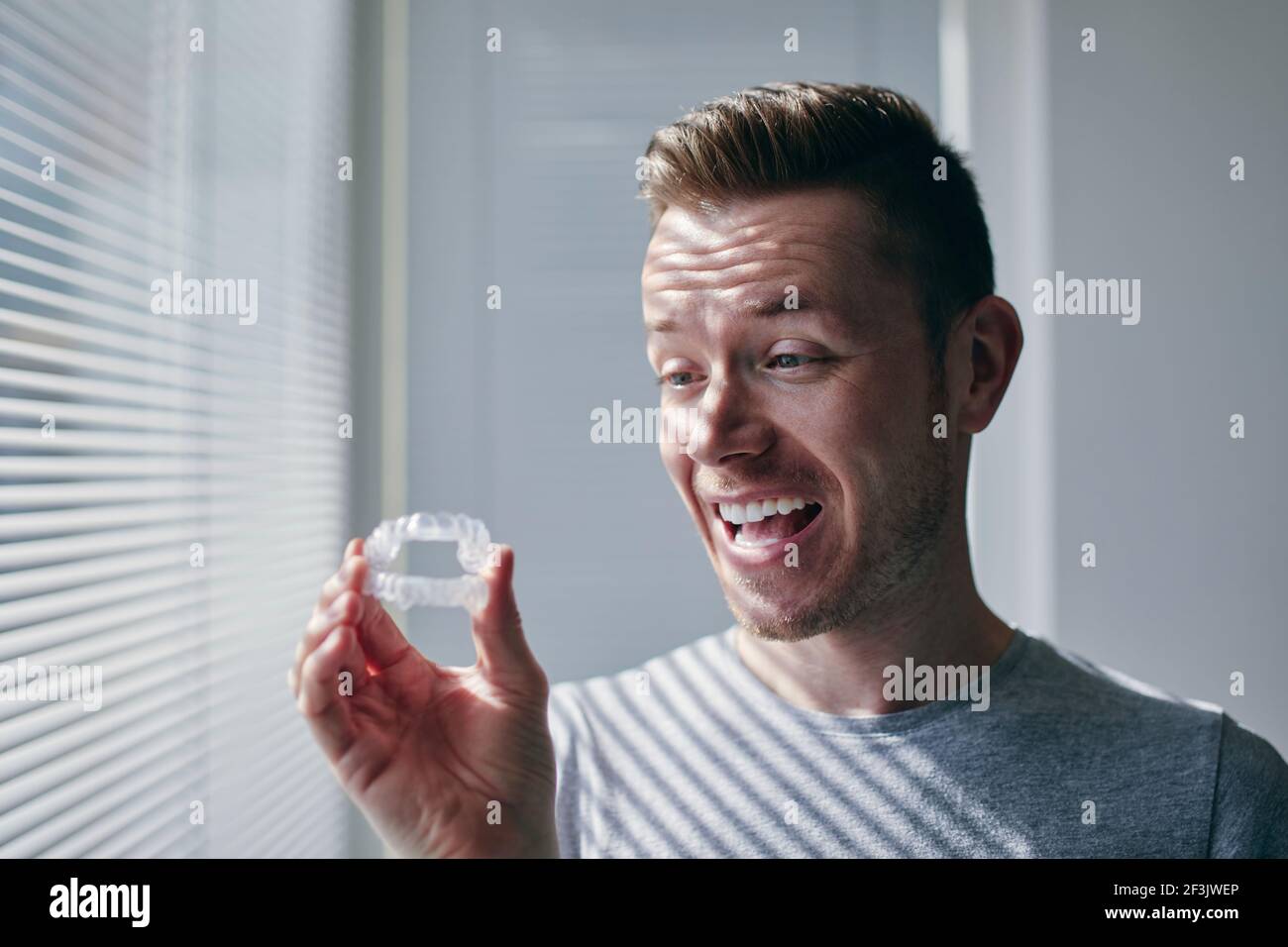 Glücklicher Mann mit toothy Lächeln hält Bleaching Tabletts. Themen Zahngesundheit, Pflege und Schönheit. Stockfoto