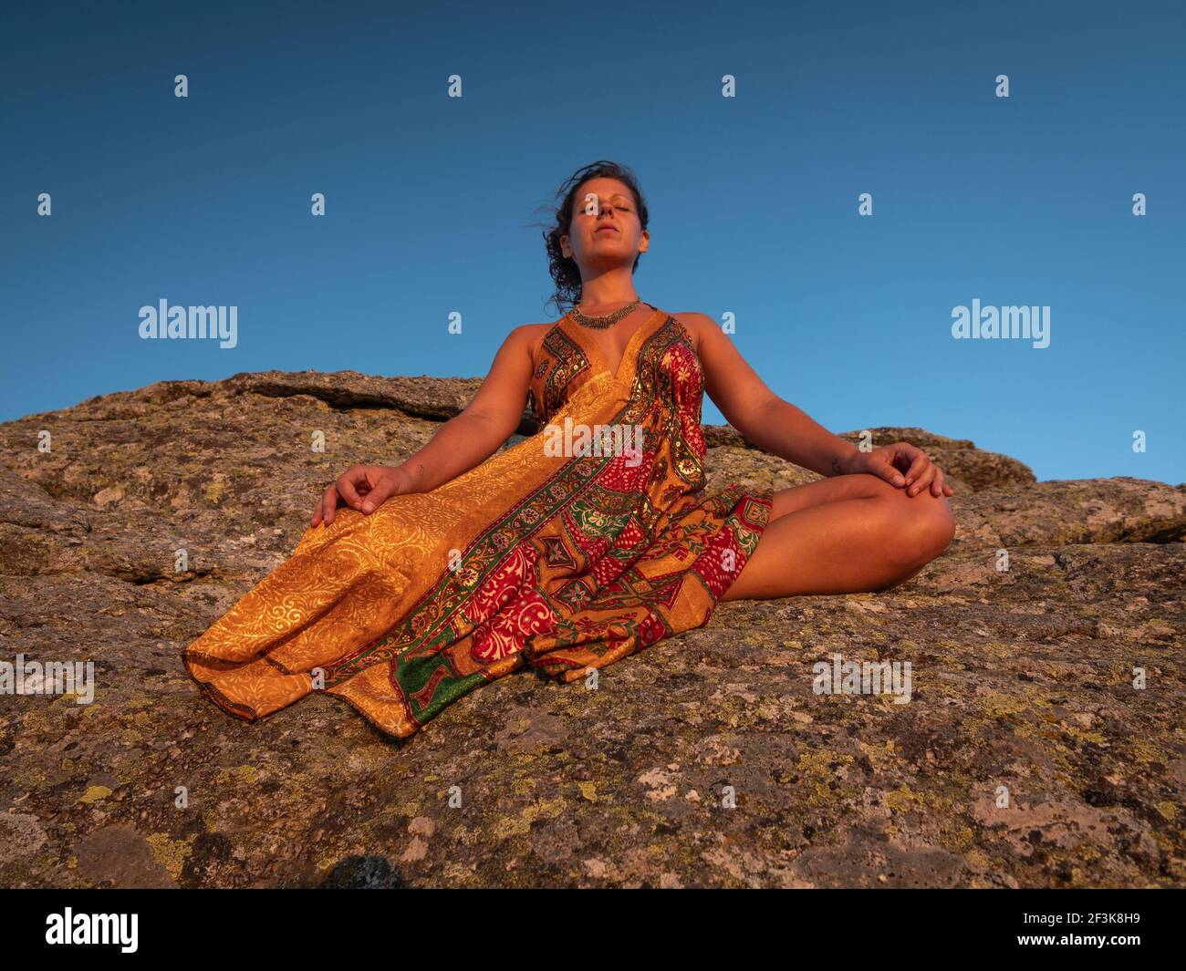 Vorderansicht des Weibchens in tief meditierender Atmung ruhig im Sonnenuntergang. Stockfoto