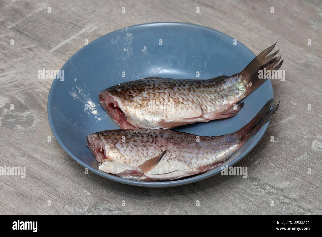 Frischer Karauschen-Karpfen-Fisch aus der Nähe auf einem Teller in der heimischen Küche. Fisch zum Braten geschält Stockfoto
