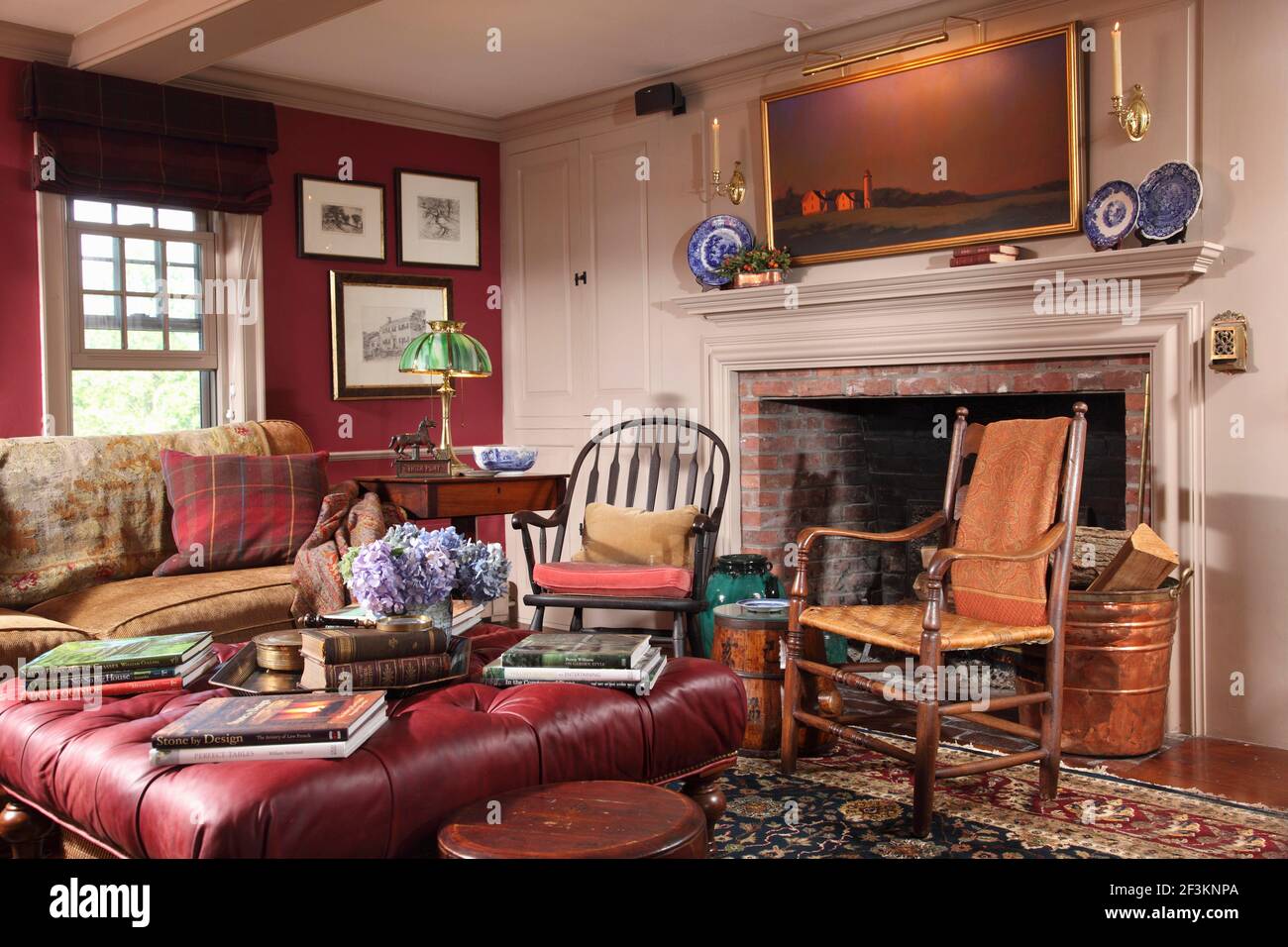 Wohnzimmer in Colonial Haus mit Kamin, und Malerei über Mantel. Übergroße  Lederhocker und legere Einrichtung im Landhausstil Stockfotografie - Alamy