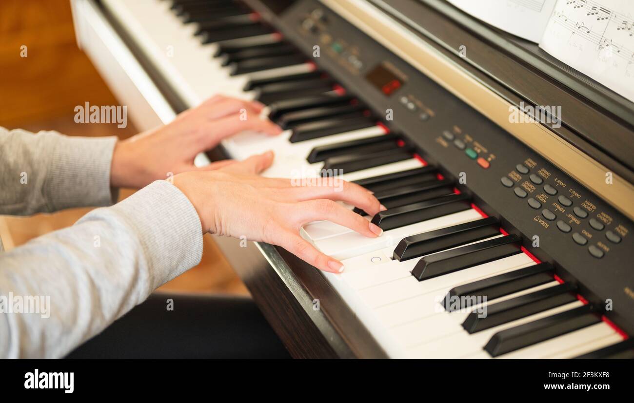 Nahaufnahme der Hände der Frau, die lernen, das elektronische Klavier zu spielen Stockfoto