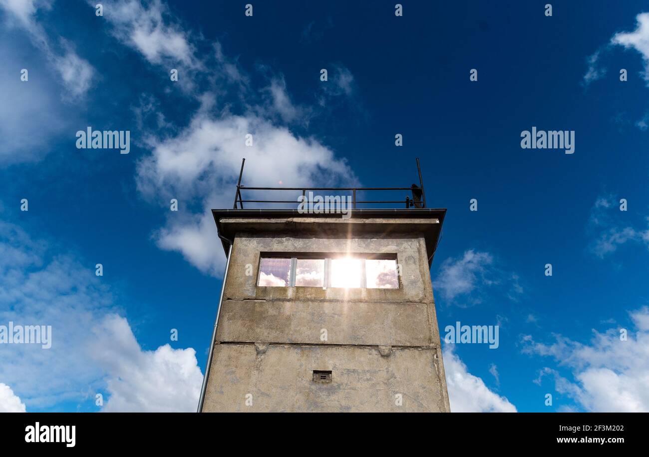 Neu Bleckede, Deutschland. März 2021, 17th. Wolken ziehen über einen Wachturm der ehemaligen Grenztruppen der DDR an den Ufern der Elbe, während Sonnenstrahlen von den Fensterscheiben des Turms reflektiert werden. Quelle: Philipp Schulze/dpa/Alamy Live News Stockfoto