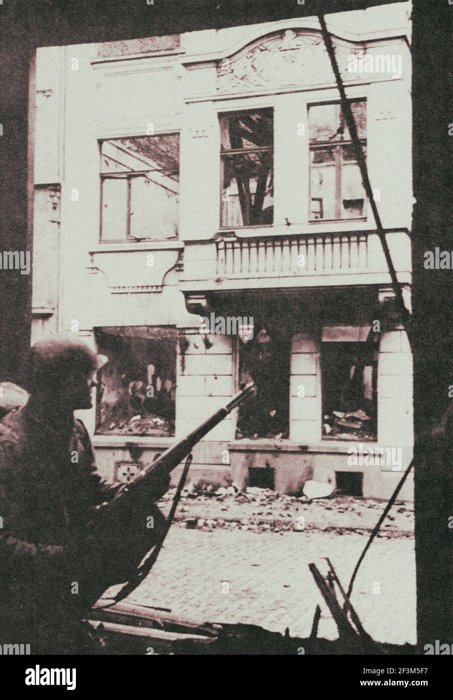 Archivfoto eines US-Soldaten, der bei einer Jagd auf deutsche Scharfschützen in Köln im März 1945 in eine Tür flüchtet. Stockfoto