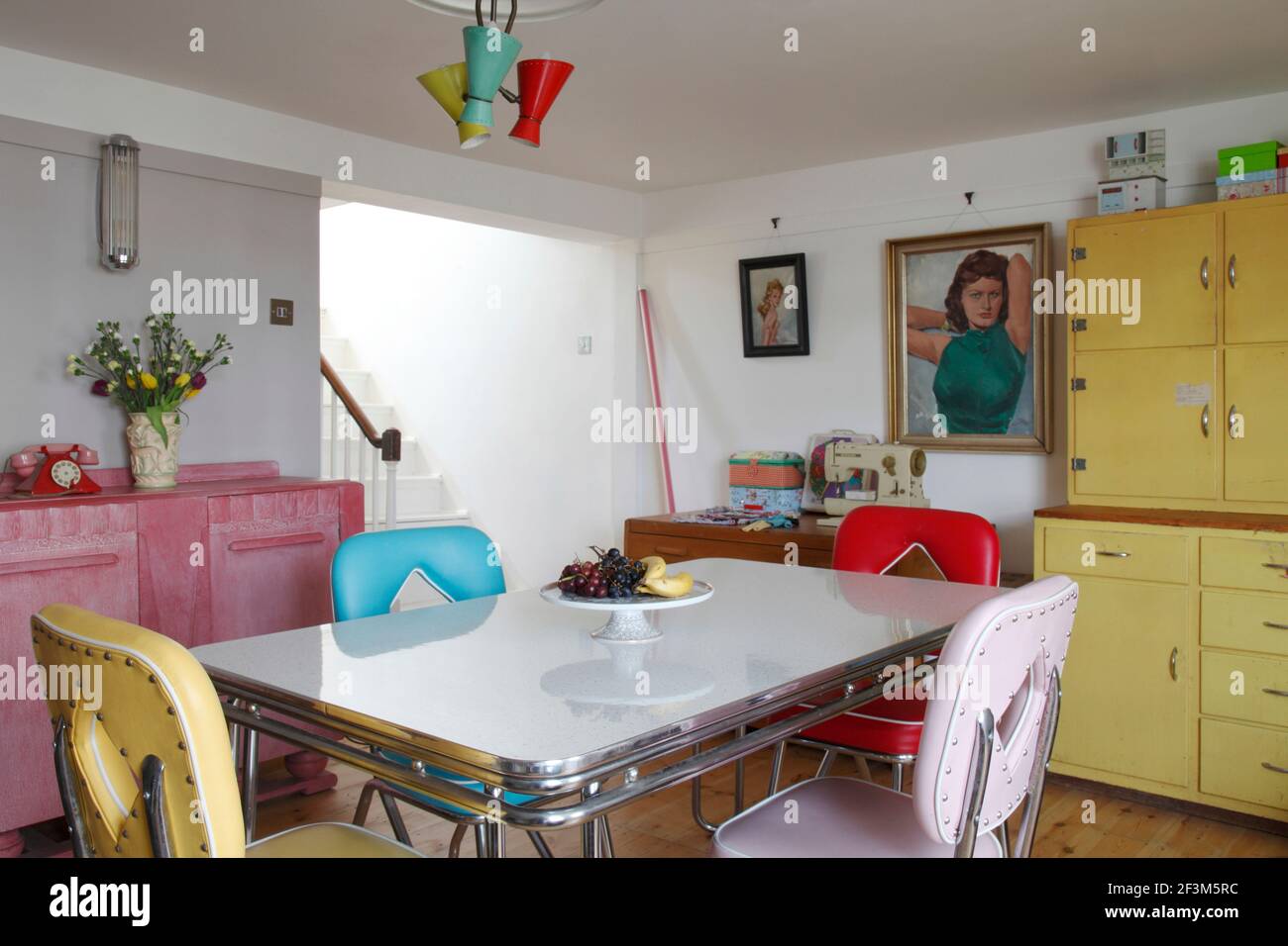 In hellen Farben gehaltene Diner-Möbel im amerikanischen Stil mit pinkem  Art Deco Sideboard & utilitaristisch gelb lackiert Küchenschrank  Stockfotografie - Alamy