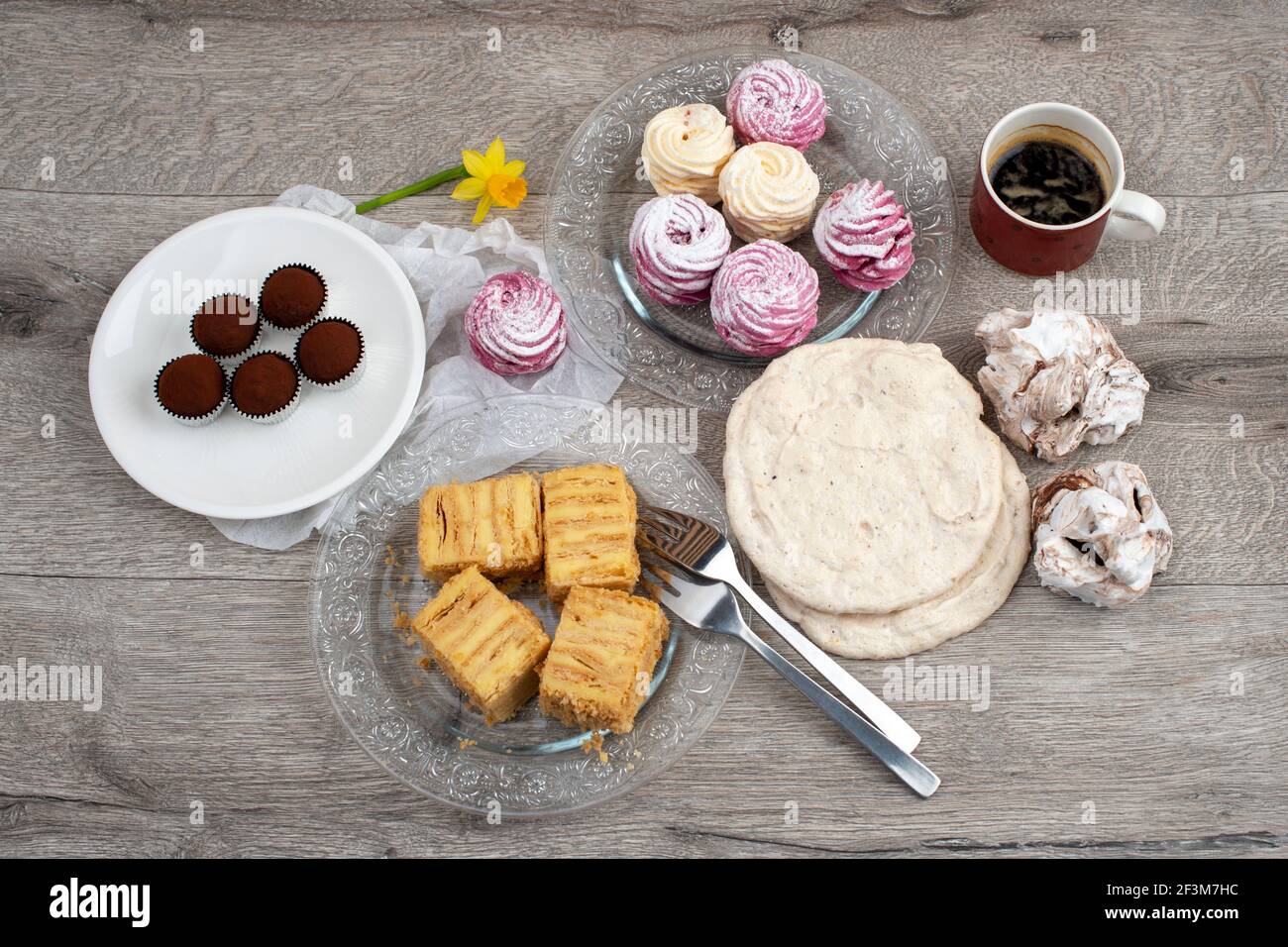 Tisch mit verschiedenen Keksen, Torten, Kuchen und einer Tasse Kaffee. Nahaufnahme, Draufsicht. Stockfoto