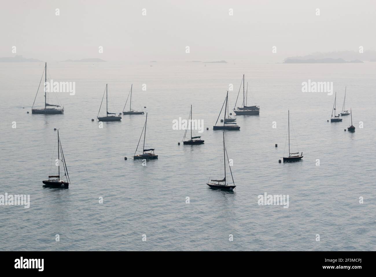 Silhouetten von verankerten Segelbooten im Nebel Stockfoto