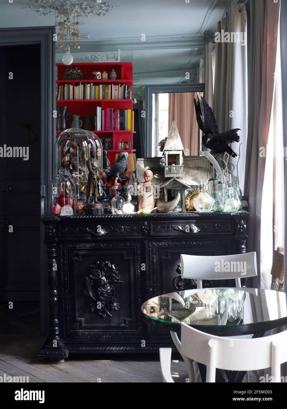 Kunstvolle schwarze Kommode mit einer Sammlung von Präparatoren und anderen  Kuriositäten und mit Spiegelung in Glastisch im Wohnhaus, Frankreich  Stockfotografie - Alamy
