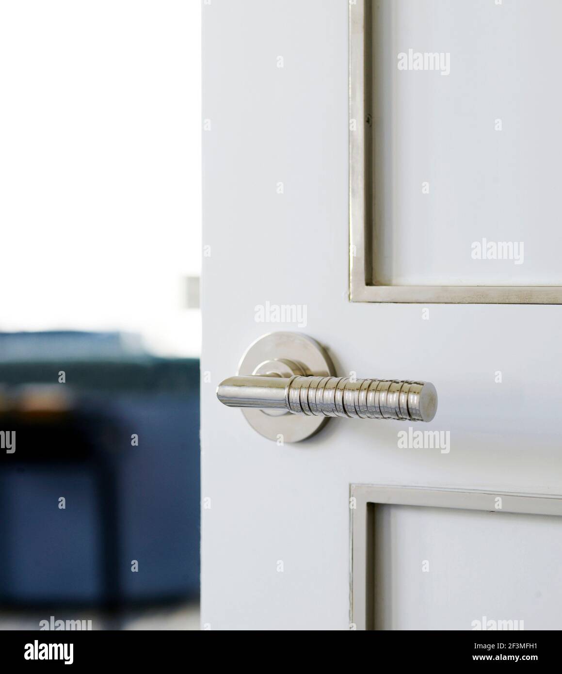 Stuhl und Aufbewahrungseinheit durch halb offene Tür in Bangkok Wohnung, Thailand gesehen Stockfoto