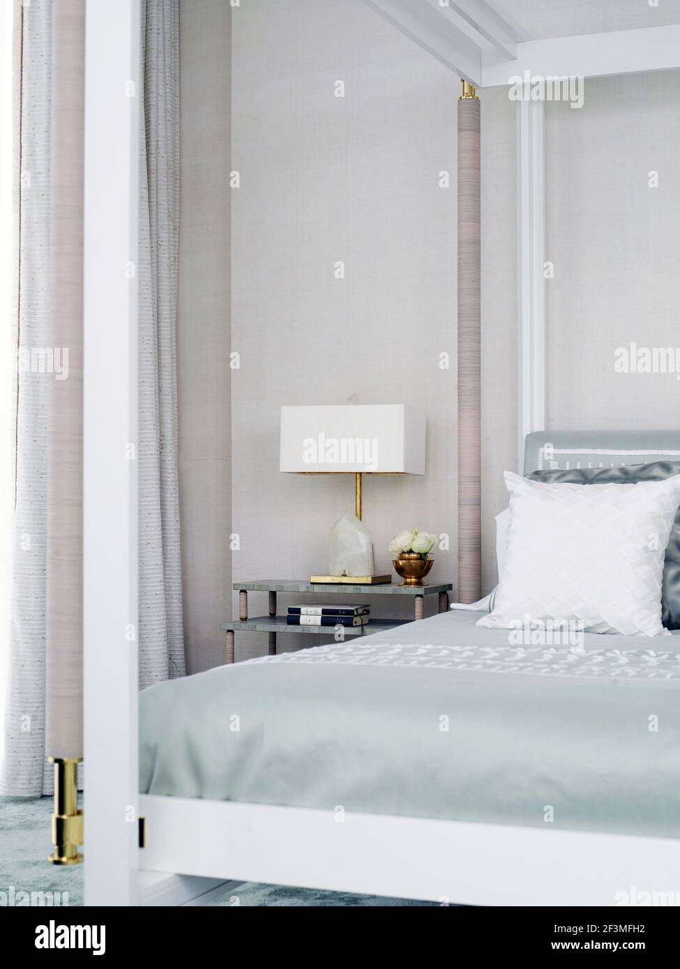 Lampe mit quadratischem Lampenschirm neben Himmelbett in Bangkok Wohnung, Thailand Stockfoto
