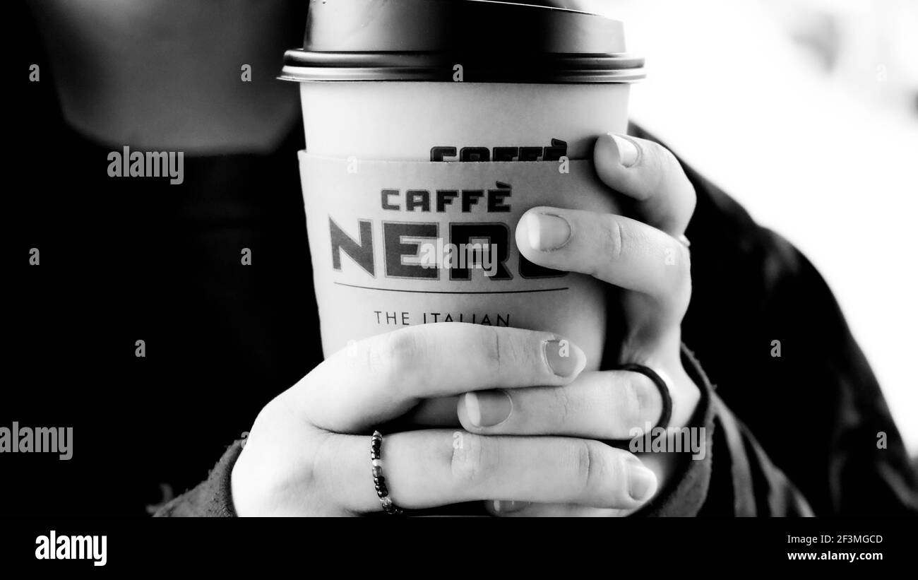 London UK, März 17 2021, Junge anonyme Frau hält EINE Tasse Kaffee Nero Takeaway Kaffee Stockfoto