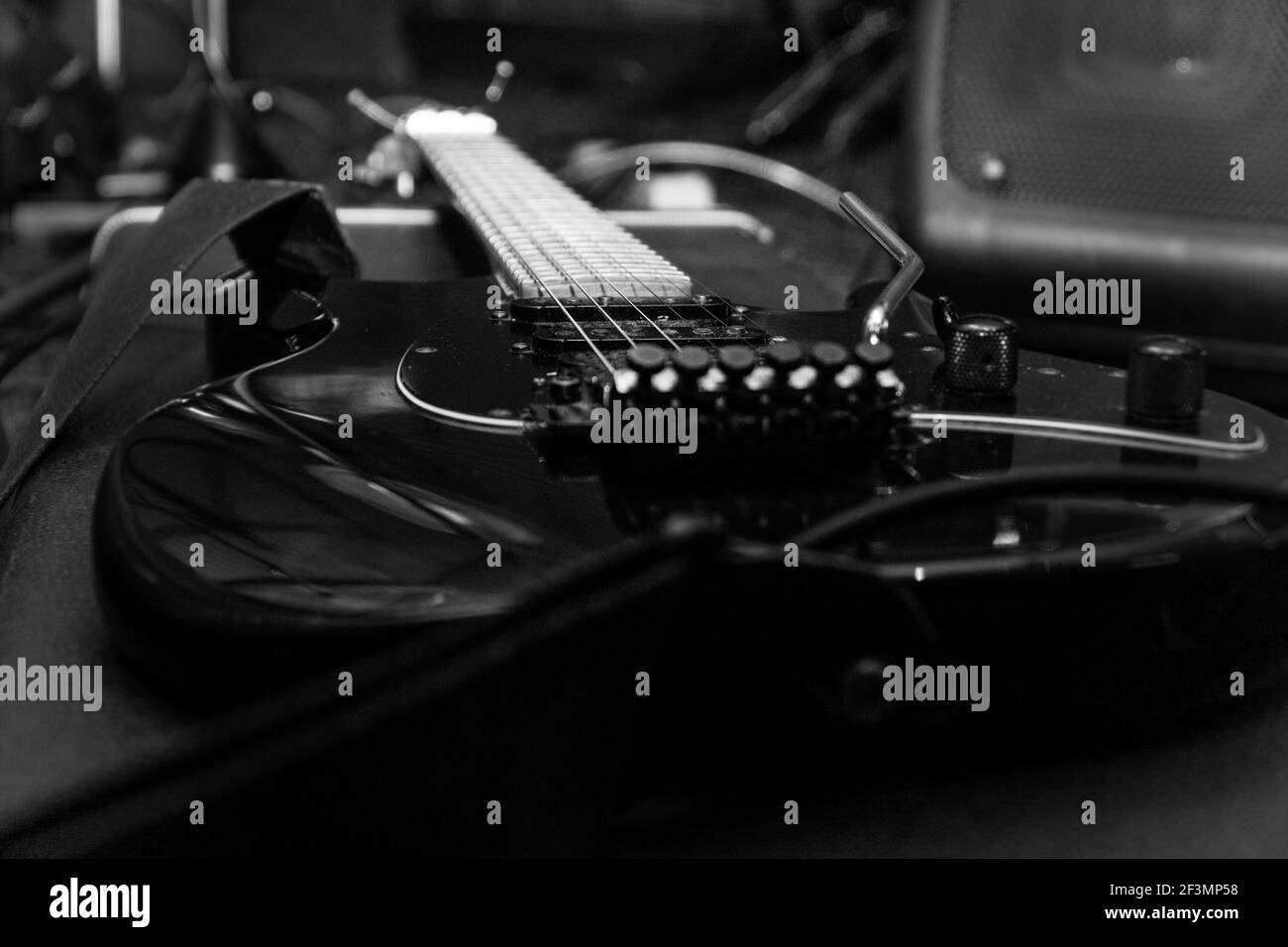 Schwarze E-Gitarre mit Tremolo auf einem Hartschalenkoffer. Selektiver Fokus Stockfoto