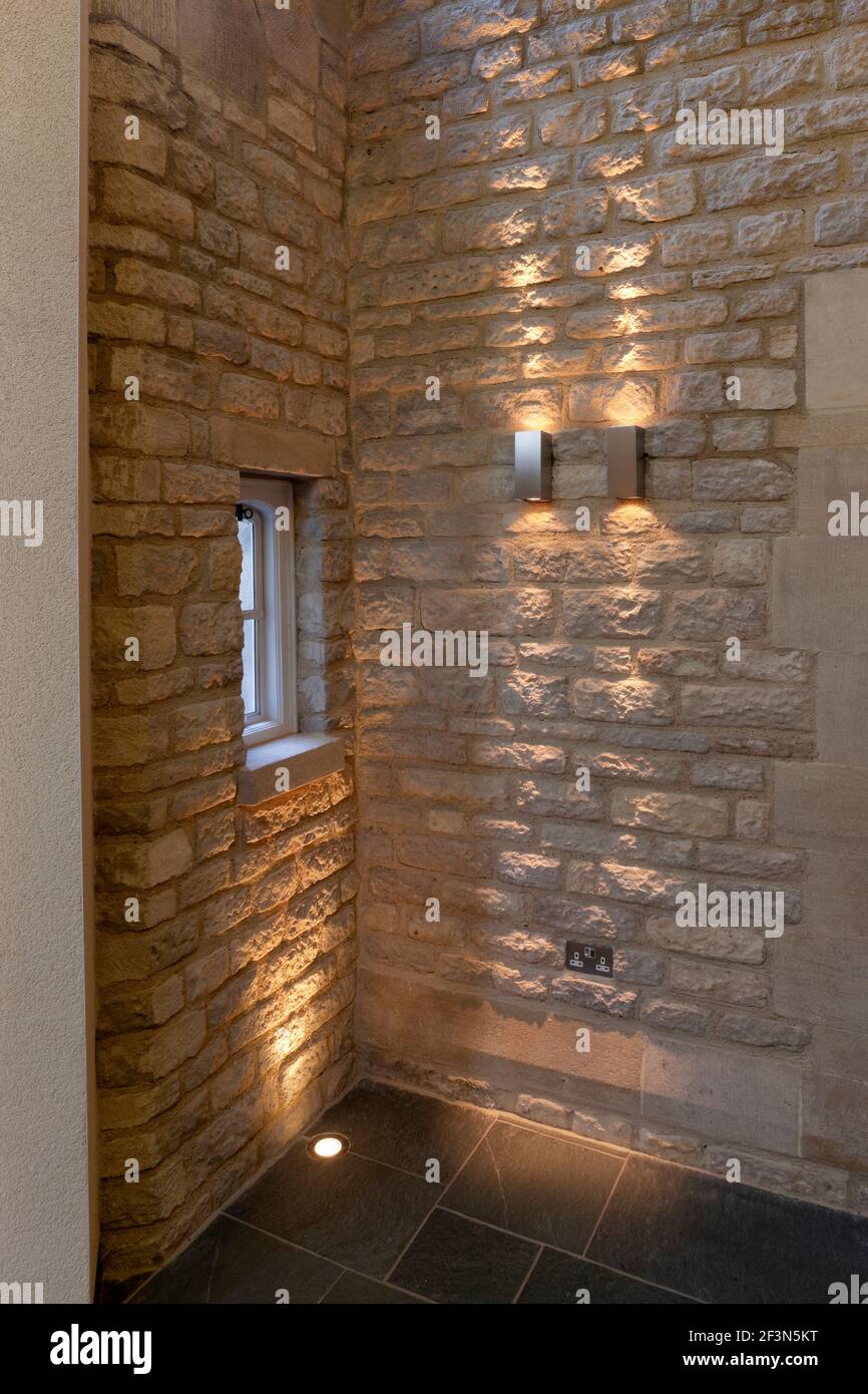 Merton College, University of Oxford, Hörsaal und Empfangsbereich. Detail der beleuchteten Steinwand und versenkten Boden Aufheller. Stockfoto