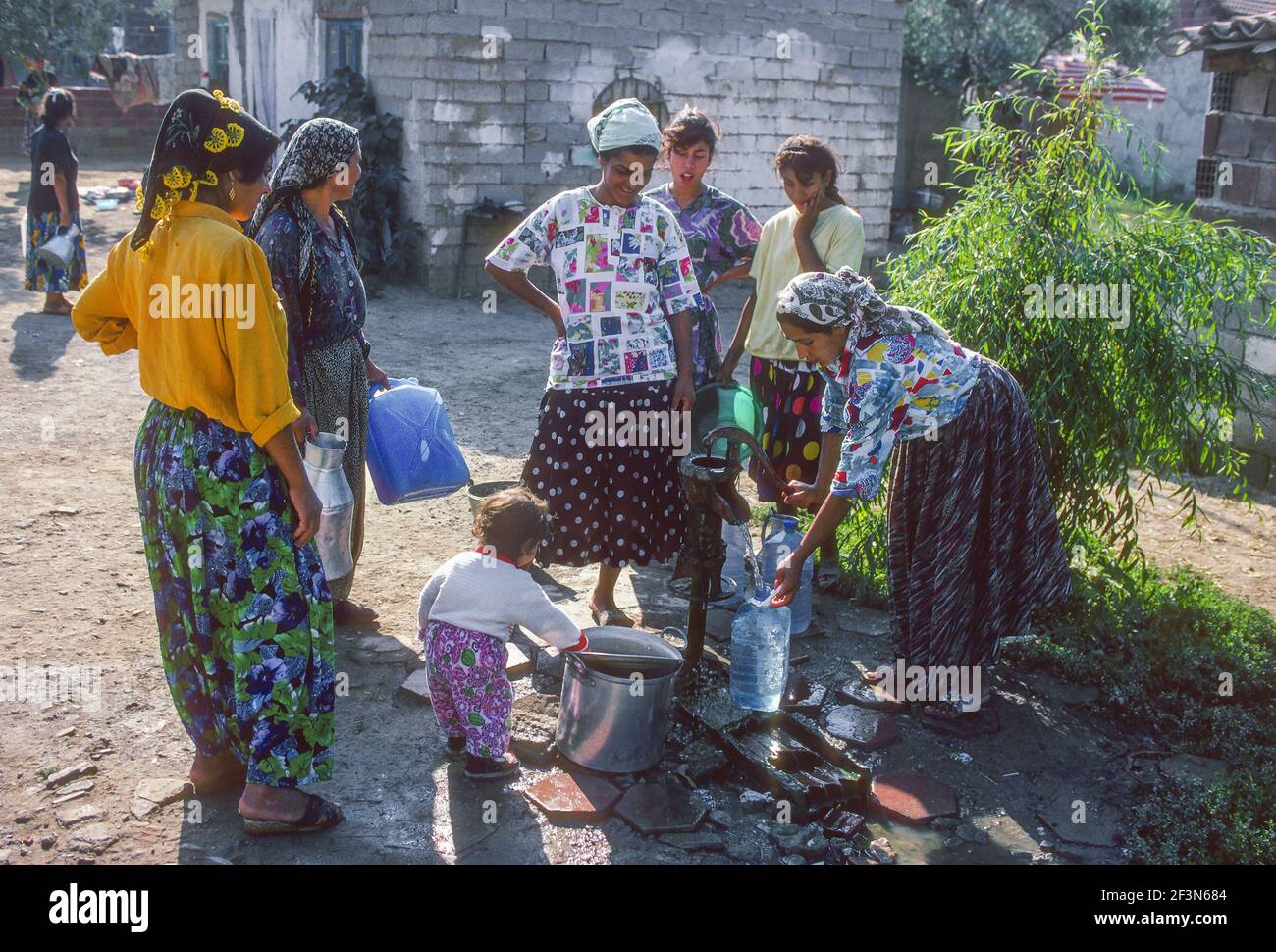 Frauen füllen Wasserbehälter aus kommunalen Wasserhahn Iznik Türkei Stockfoto