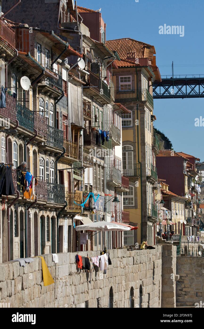 Ribeira (am Wasser) Bezirk von Porto mit mittelalterlicher Mauer unten und 5-stöckige Häuser mit Balkon und Hängewaschgang mit Ponte Dom Luis 1 im Bac Stockfoto