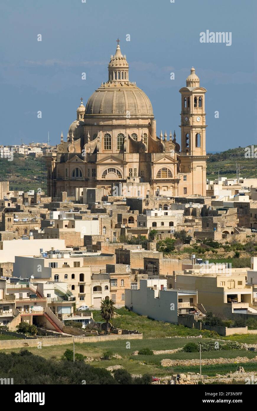 Der Blick über die Felder nach Xewkija auf Gozo wird von der beeindruckenden Kuppel der Kirche dominiert, die Sitz der Ritter des Ordens von St. John ist. Stockfoto