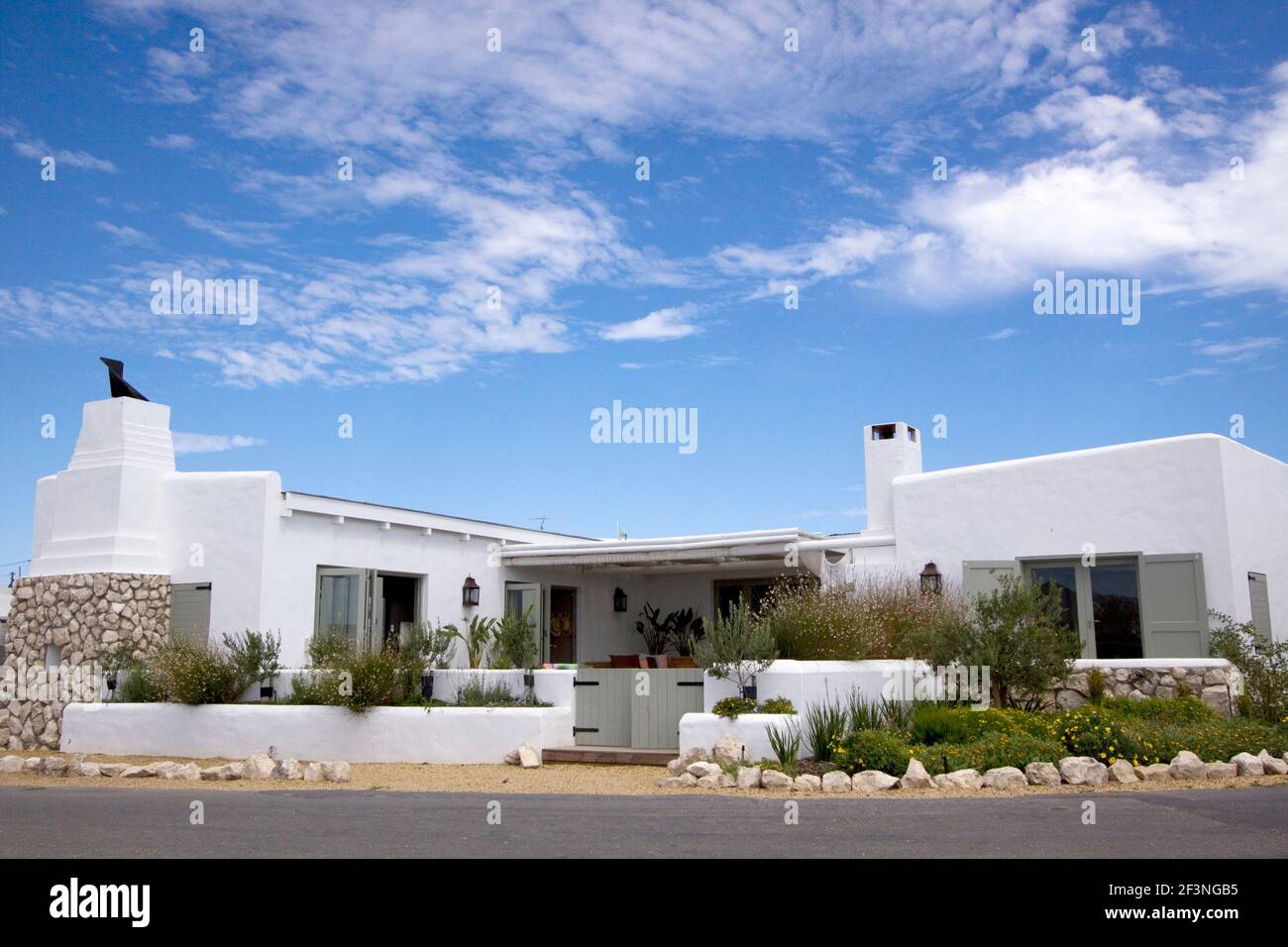 Traditionelles Strandhaus in Paternoster Südafrika mit weiß getünchten Wänden, Steinfirplace in einem Garten mit Olivenbäumen und indigineous Pflanzen gesetzt Stockfoto
