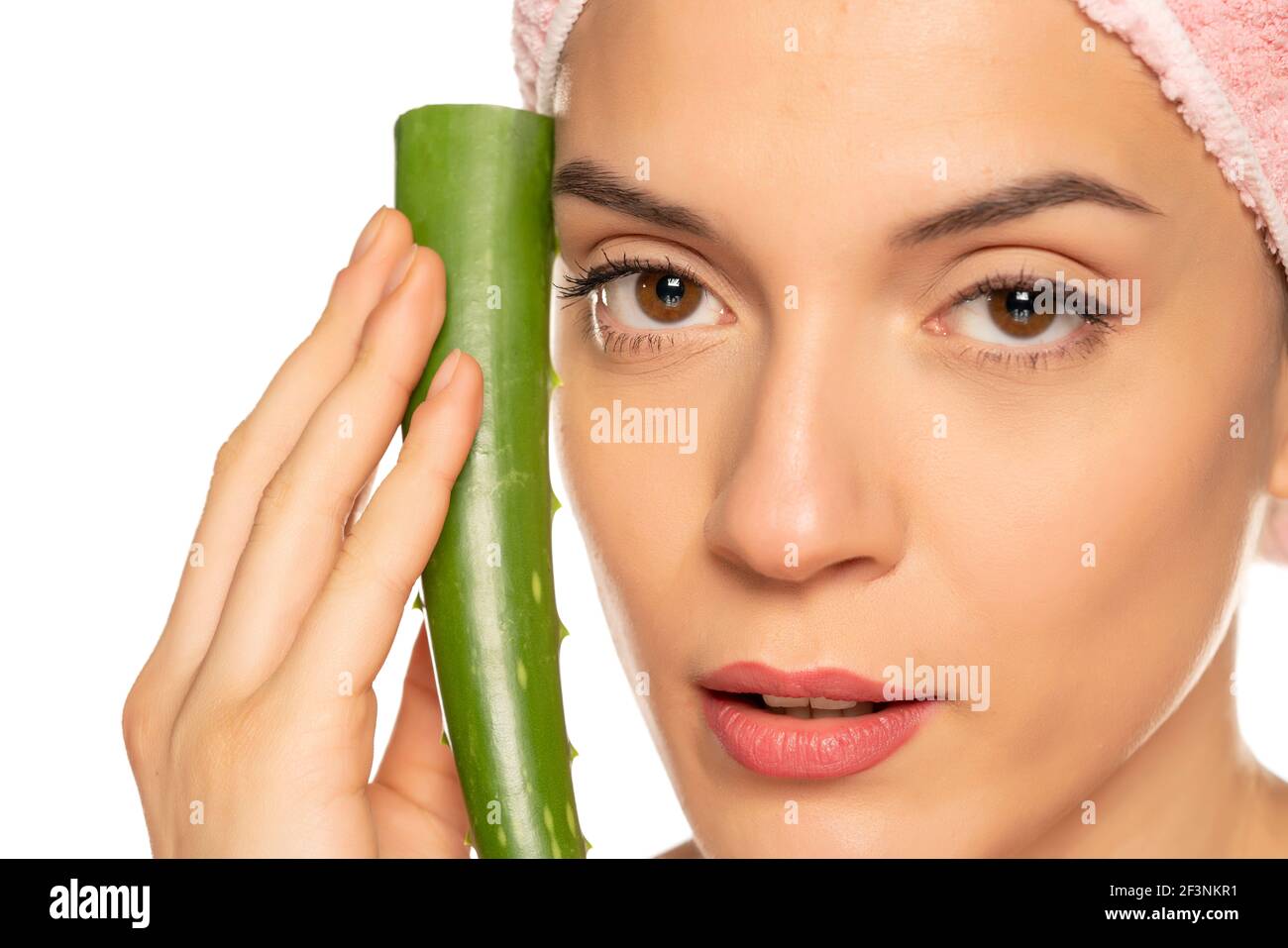 Junge schöne Frau posiert mit einem Blatt Aloe Vera Auf weißem Hintergrund Stockfoto