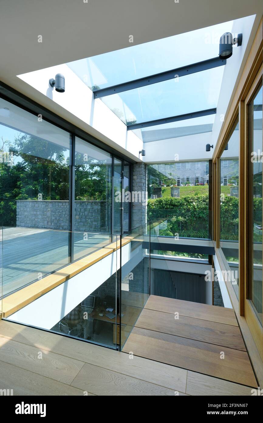 Das Innere eines modernen Hauses an der Küste. Große Glasschiebetüren öffnen sich. Raumhohe Glaspaneele. Ein flaches Gebäude in einer Lage am Meer Stockfoto