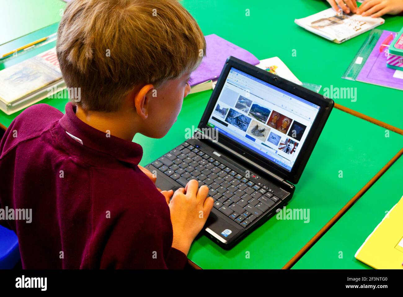 Grundschulkind, das während eines Unterrichtseinrichts einen Laptop verwendet. Stockfoto