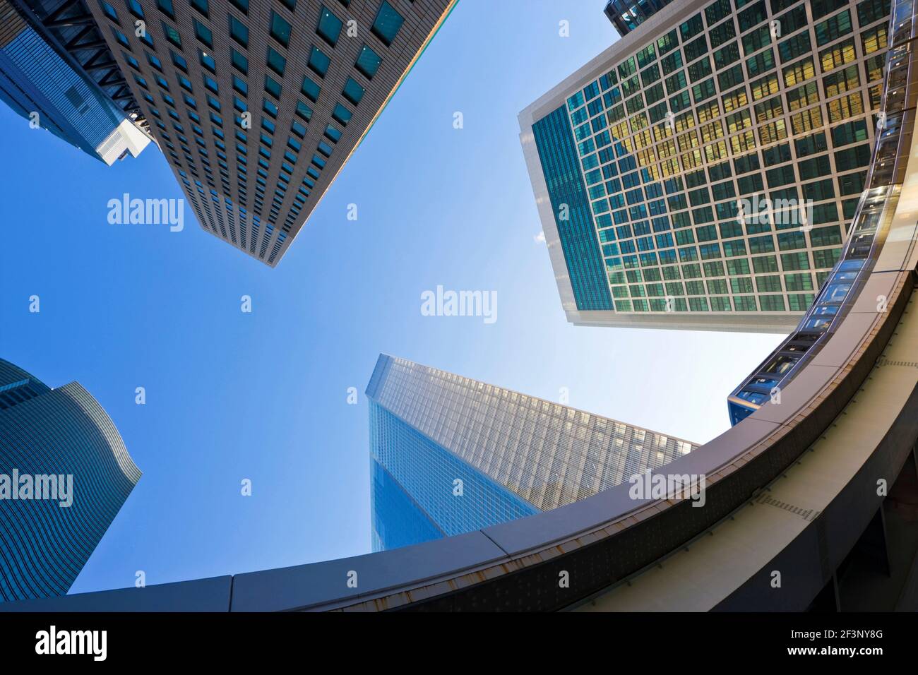 Eine niedrige Weitwinkelansicht zeigt einen vorbeifahrenden Zug auf der erhöhten Yurikamome-Linie und viele der neuen Wolkenkratzer im Shiodome-Geschäftskomplex Stret Stockfoto
