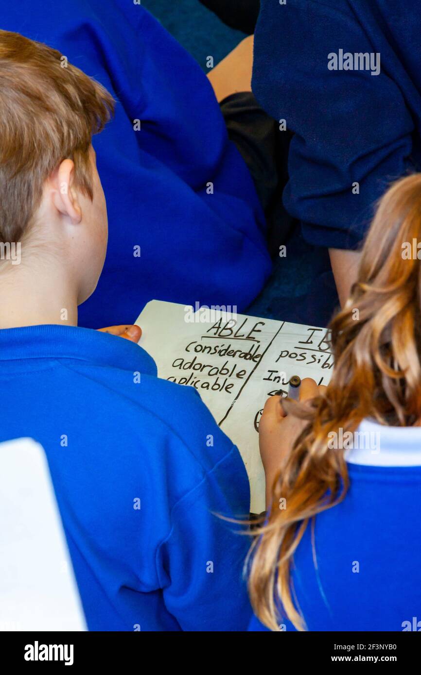 Grundschulkinder, die während einer Rechtschreibstunde Wörter schreiben. Stockfoto