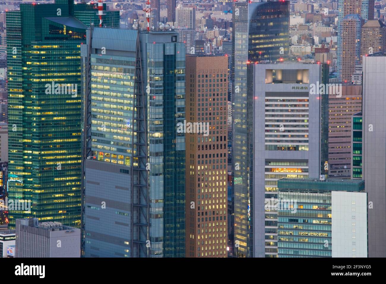 Eine Tele-Ansicht in der Dämmerung zeigt den Shiodome Business Complex, der sich hoch über umliegenden Gebäuden im Shimbashi District im Zentrum Tokios, Japan, erhebt Stockfoto