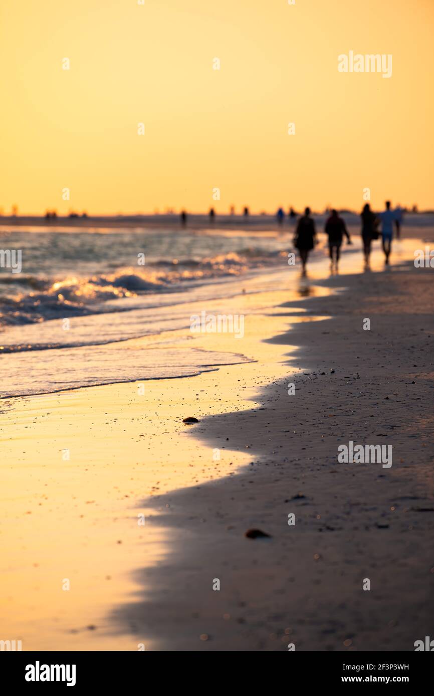 Sonnenuntergang Sonne in Siesta Key, Florida in Sarasota, USA mit Küste Ozean Golf von mexiko und Silhouette von Menschen Paare am Strand zu Fuß Stockfoto