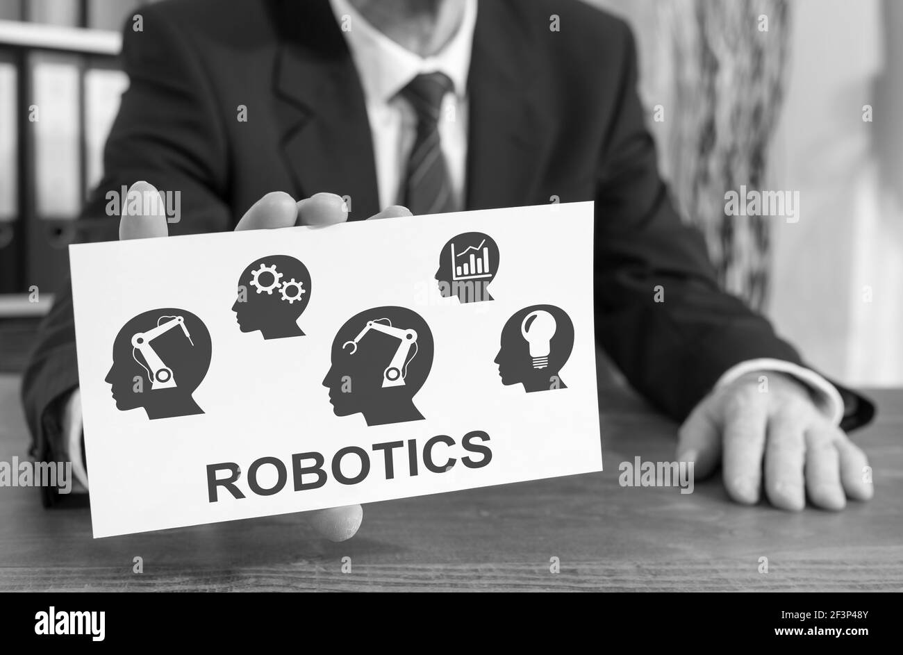 Geschäftsmann zeigt eine Karteikarte mit Roboterkonzept Stockfoto