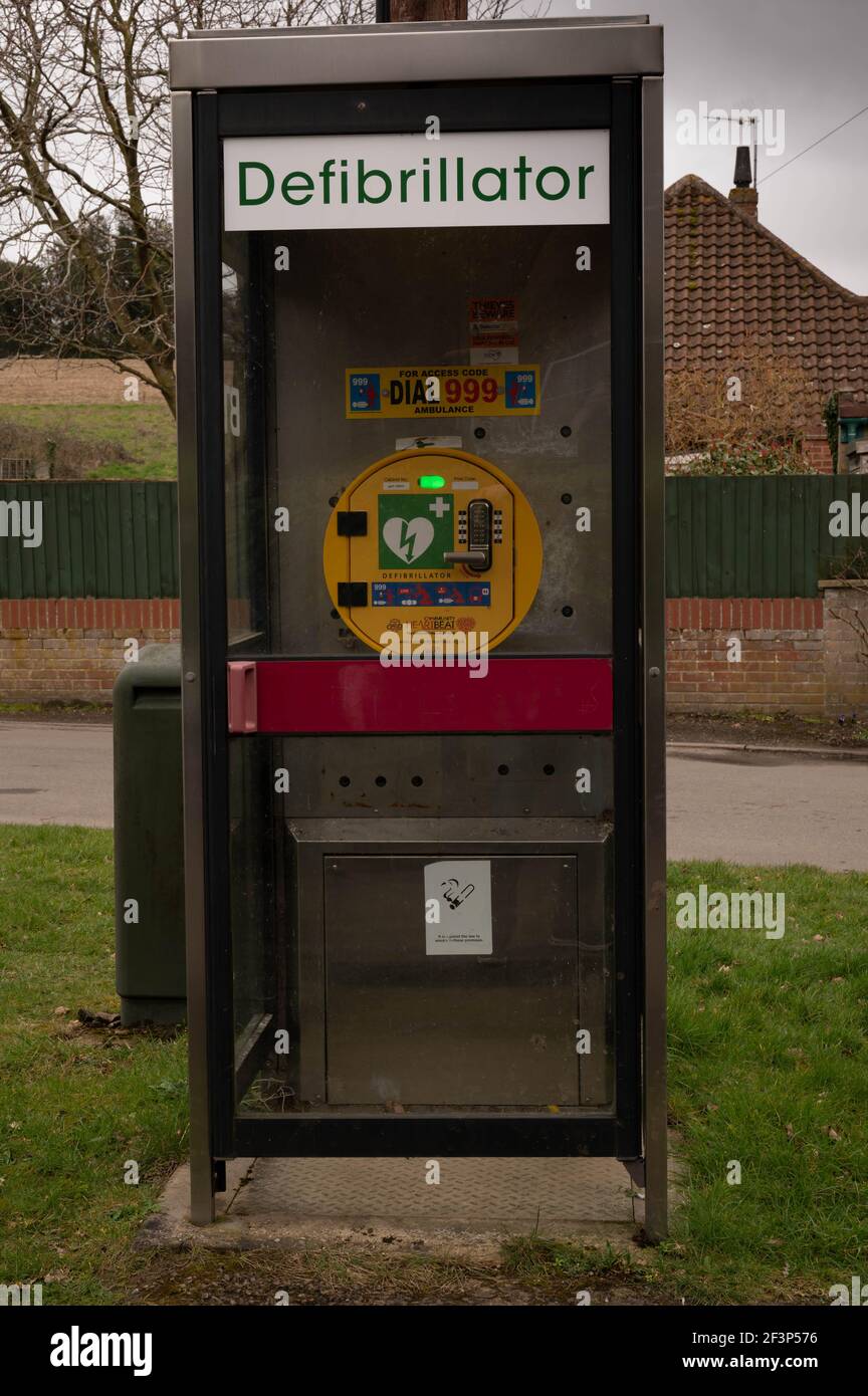 Ein Notfall-Herzdefibrillator in einer alten Telefonbox in einem ländlichen englischen Dorf Stockfoto