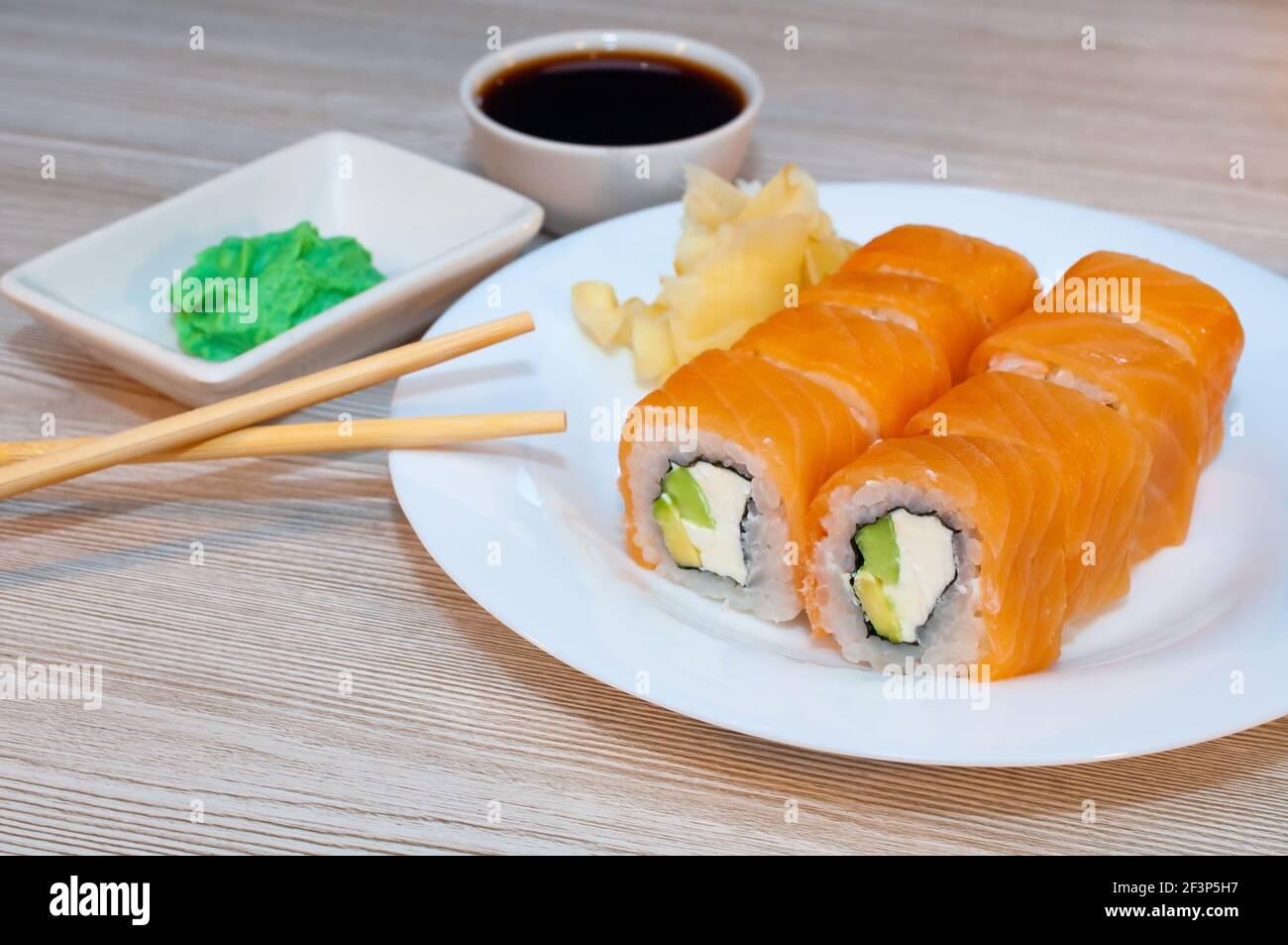 Brötchen mit Fisch Avocado und Gurke in einem Teller mit sojasauce und Wasabi Stockfoto