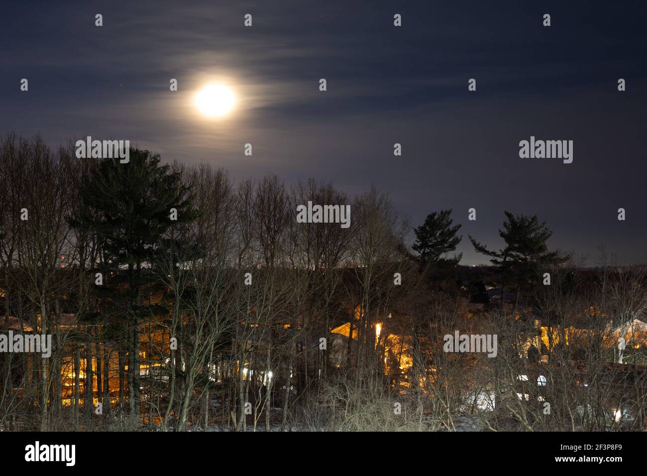 Blick auf die Stadt bei Nacht mit Vollmond am dunklen Himmel Stockfoto