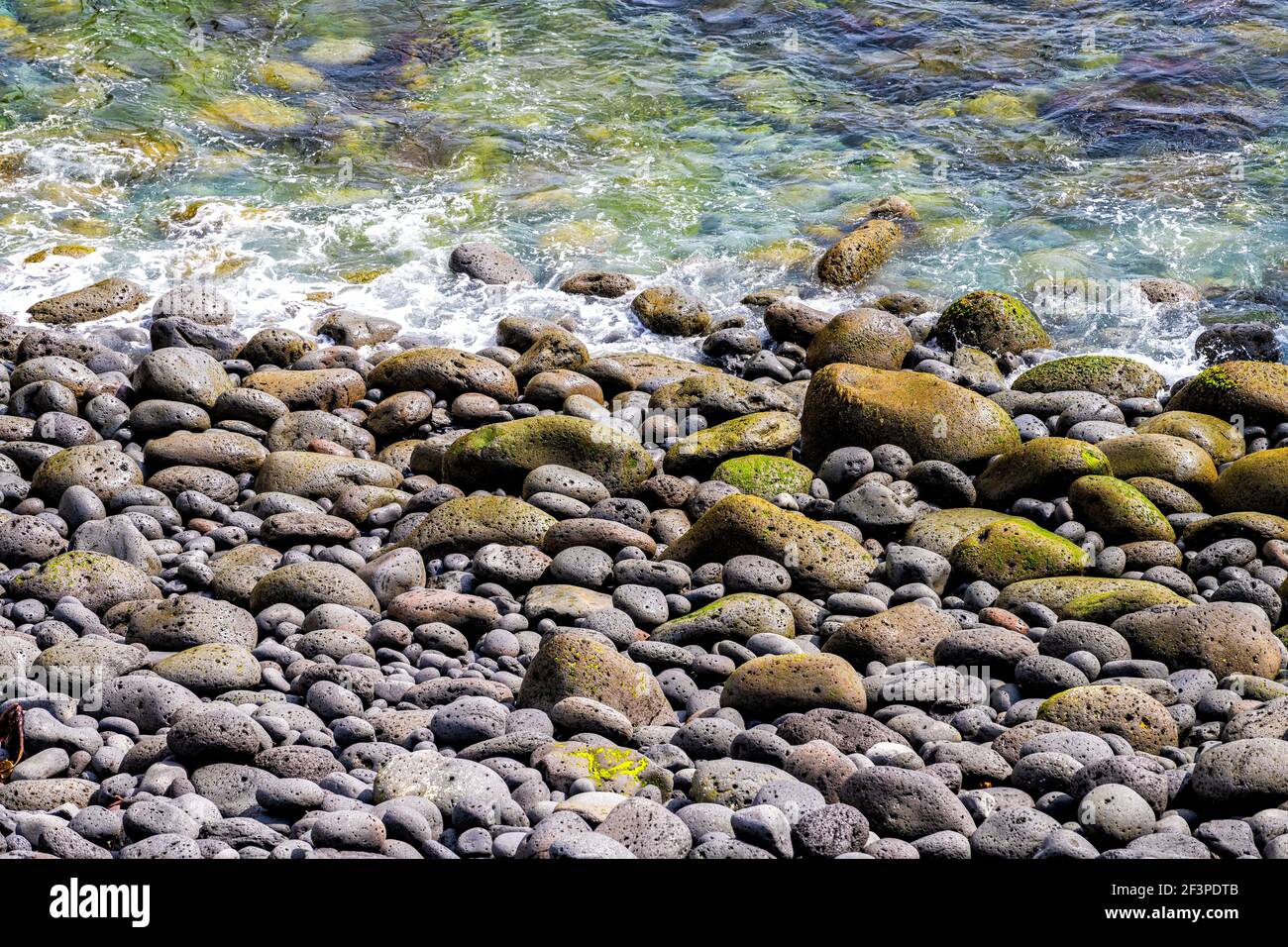 Nahaufnahme Ufer abstrakte Landschaft Blick in der Nähe Gatklettur Bogen Felsen in der Nähe Hellnar Nationalpark Snaefellsnes Halbinsel in Island mit Steinen Felsen Splashi Stockfoto