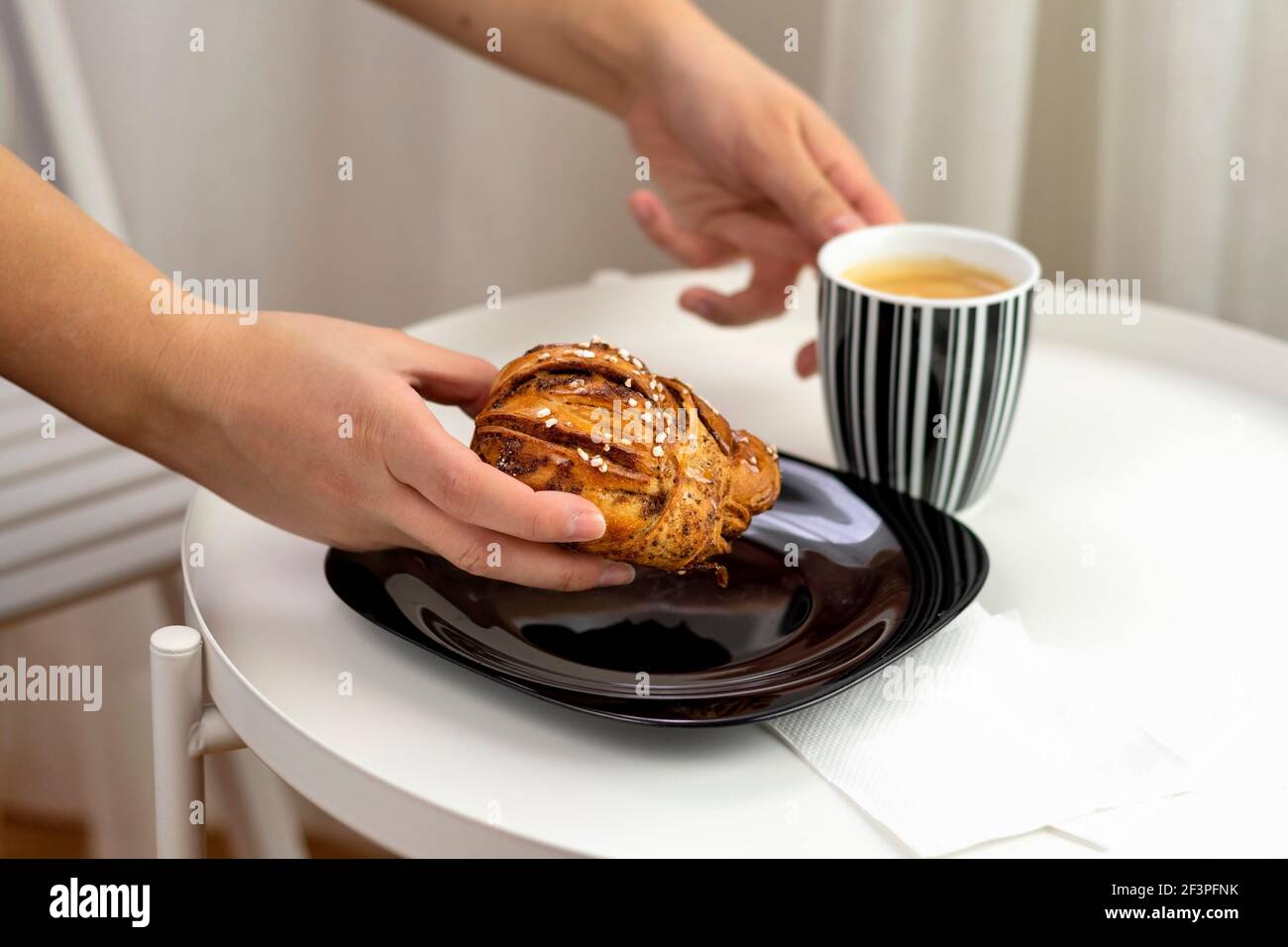 Hand der Frau hält köstliche schwedische Zimtbrötchen, Kanelbullar. Stockfoto