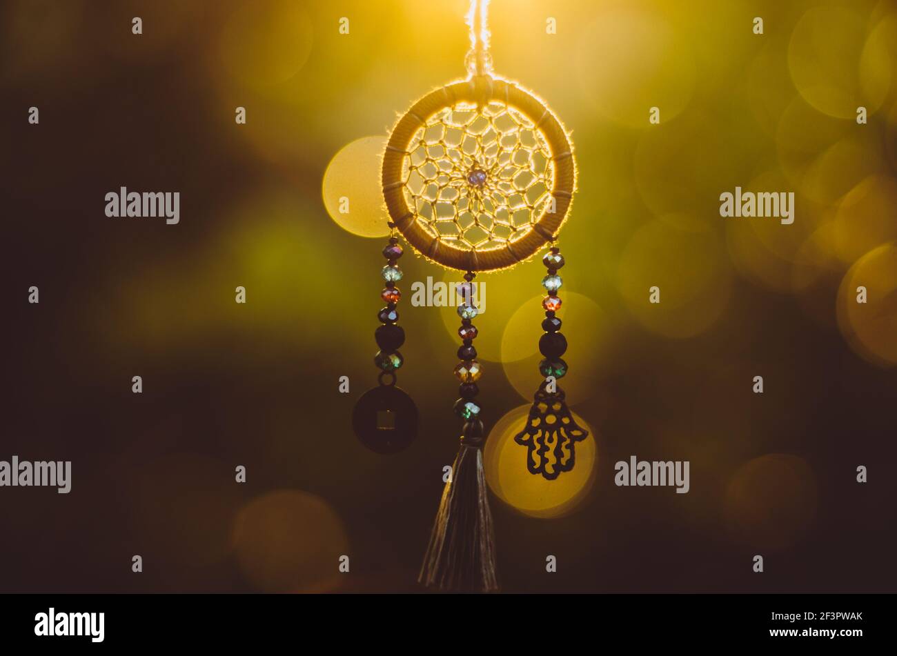 Nahaufnahme der spirituellen Halskette mit heiligen Geometrie Kreis mit Bokeh Hintergrund beleuchtet durch Sonnenuntergang goldenes Licht Stockfoto