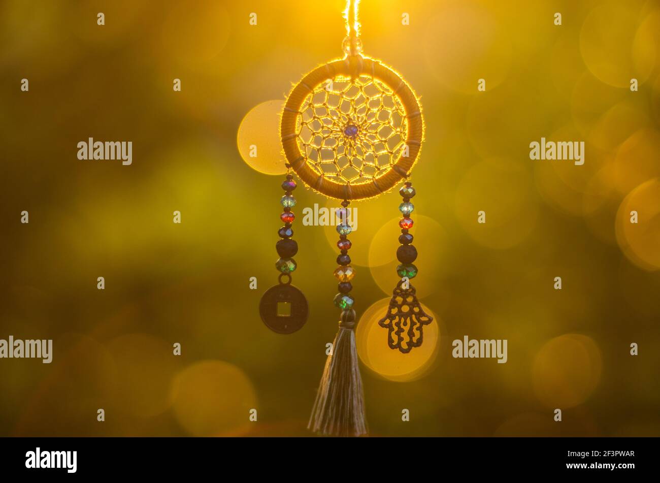 Nahaufnahme der spirituellen Halskette mit heiligen Geometrie Kreis mit Bokeh Hintergrund beleuchtet durch Sonnenuntergang goldenes Licht Stockfoto