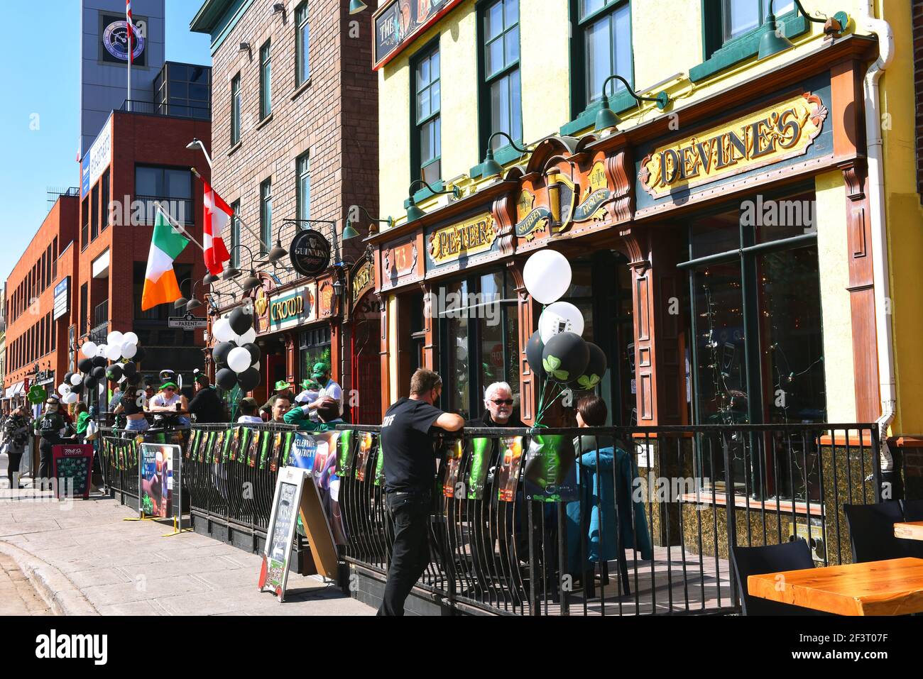 Ottawa, Kanada - 17. März 2021: Wegen der Covid-19-Beschränkungen feiert ein viel kleineres Publikum den St. Patrick's Day im beliebten Irish Pub The Irish Village. Das warme Wetter machte es möglich, auf der Terrasse zu sitzen. Stockfoto