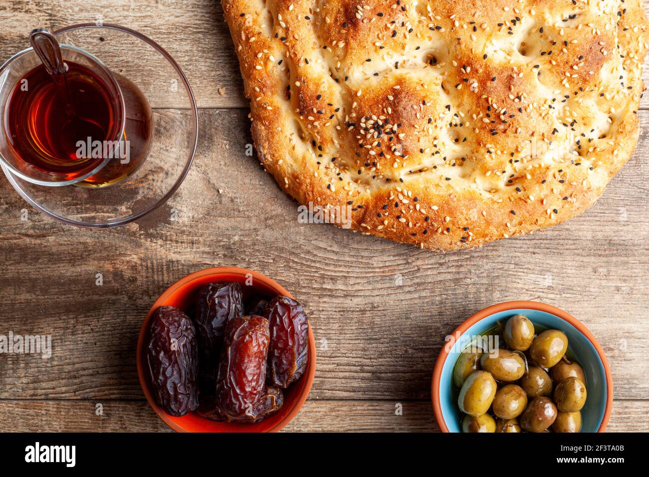 Flaches Lay-Bild einer traditionellen Mahlzeit für Iftar und Sahur im heiligen Fastenmonat Ramadan. Türkischer Tee in speziellen Gläsern, ramazan Pidesi, ein Typ Stockfoto