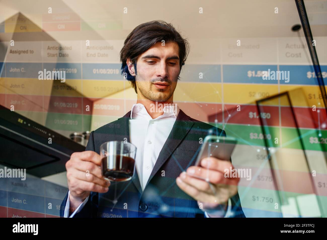 Geschäftsmann arbeitet vom Smartphone aus, während er zu Hause einen Kaffee trinkt Stockfoto