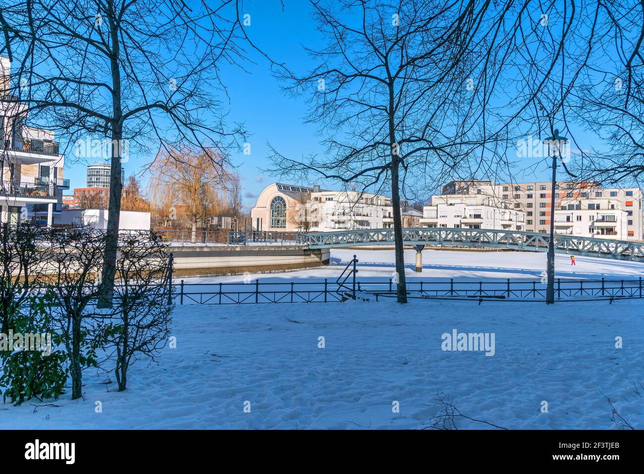 Berlin, Deutschland - 12. Februar 2021: Gefrorenes Hafenbecken Tegeler Hafen mit Fußgängerbrücke, moderne Wohngebäude und die Humboldt-Bibliothek Stockfoto