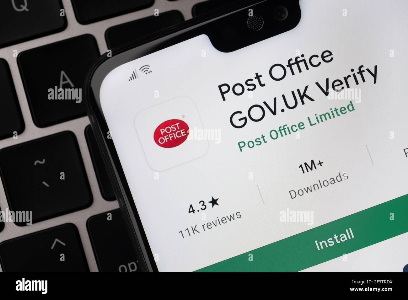 Britische Post Office-App auf dem Bildschirm auf dem Smartphone, das auf der Laptop-Tastatur platziert wird gesehen. Stafford, Großbritannien, 14. März 2021 Stockfoto