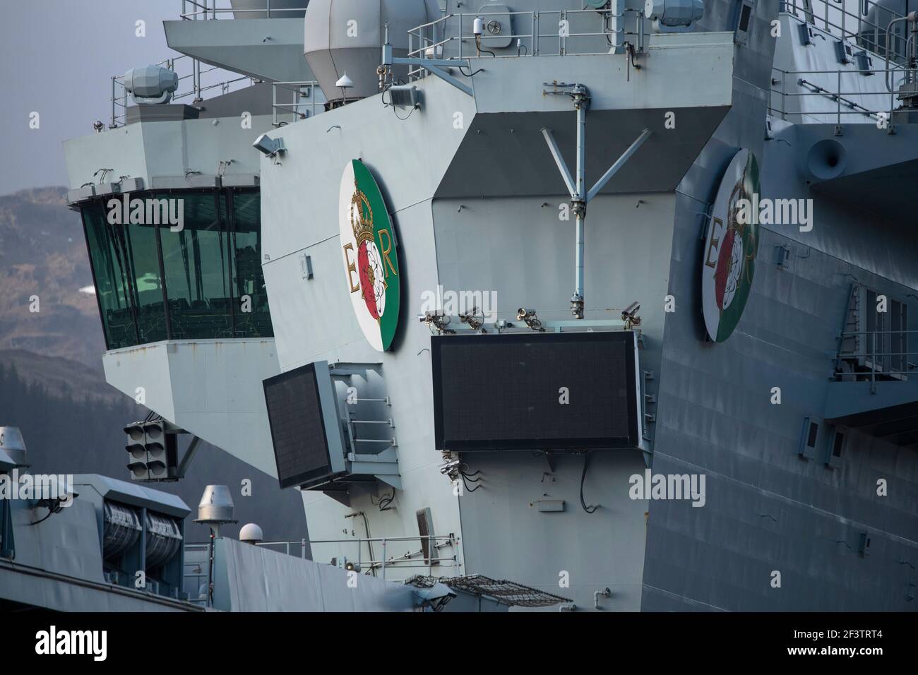 Finnart, Loch Long, Schottland, Großbritannien. 17. März 2021. Queen Elizabeth Plaketten auf dem Turm. HMS Queen Elizabeth ist das größte und fortschrittlichste Kriegsschiff, das jemals für die Royal Navy gebaut wurde. Sowohl HMS Queen Elizabeth (im Bild) als auch HMS Prince of Wales sind die Flaggschiffe der Nation, die 65.000 Tonnen wiegen und 280 Meter lang sind. Die Aircraft Carrier liegt derzeit an der Seite des Long Loch in Glen Mallan und übernimmt Treibstoff, Munition und andere Vorräte, bevor die Marineübungen, die Teil der britischen Carrier Strike Group 2021 sind, durchgeführt werden. Das Schiff soll am Sonntag abreisen. Quelle: Colin Fisher Stockfoto Finnart, Loch Long, Schottland, Großbritannien. 17. März 2021. Queen Elizabeth Plaketten auf dem Turm. HMS Queen Elizabeth ist das größte und fortschrittlichste Kriegsschiff, das jemals für die Royal Navy gebaut wurde. Sowohl HMS Queen Elizabeth (im Bild) als auch HMS Prince of Wales sind die Flaggschiffe der Nation, die 65.000 Tonnen wiegen und 280 Meter lang sind. Die Aircraft Carrier liegt derzeit an der Seite des Long Loch in Glen Mallan und übernimmt Treibstoff, Munition und andere Vorräte, bevor die Marineübungen, die Teil der britischen Carrier Strike Group 2021 sind, durchgeführt werden. Das Schiff soll am Sonntag abreisen. Quelle: Colin Fisher Stockfoto