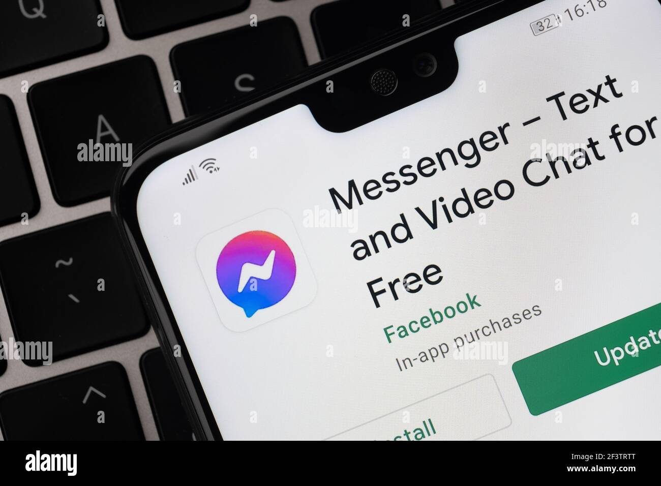 Facebook Messenger App auf dem Bildschirm auf dem Smartphone, das auf der Laptop-Tastatur platziert wird gesehen. Stafford, Großbritannien, 14. März 2021 Stockfoto