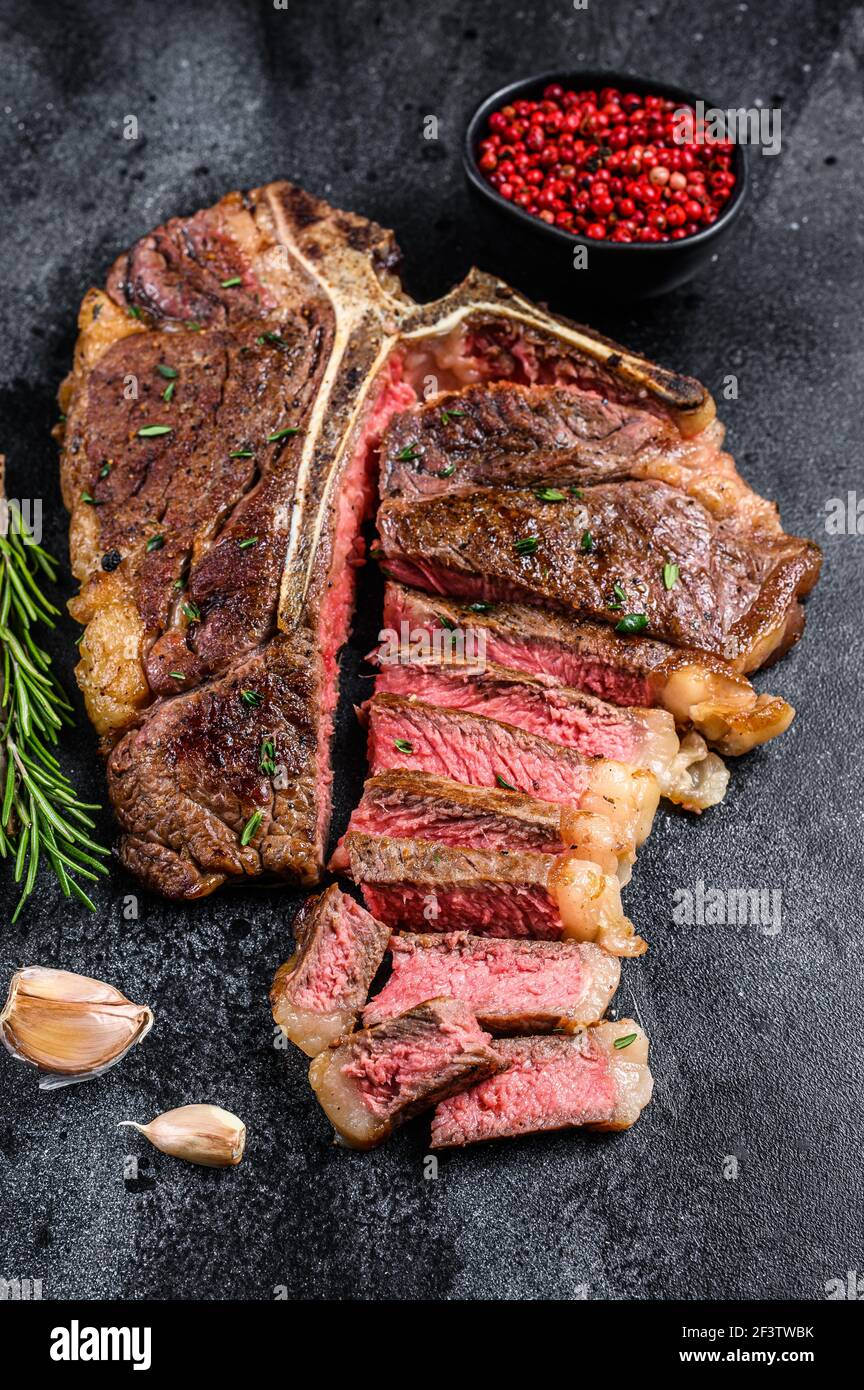 Gegrilltes italienisches Florentiner oder Rindersteak mit Knochen. Schwarzer Hintergrund. Draufsicht Stockfoto