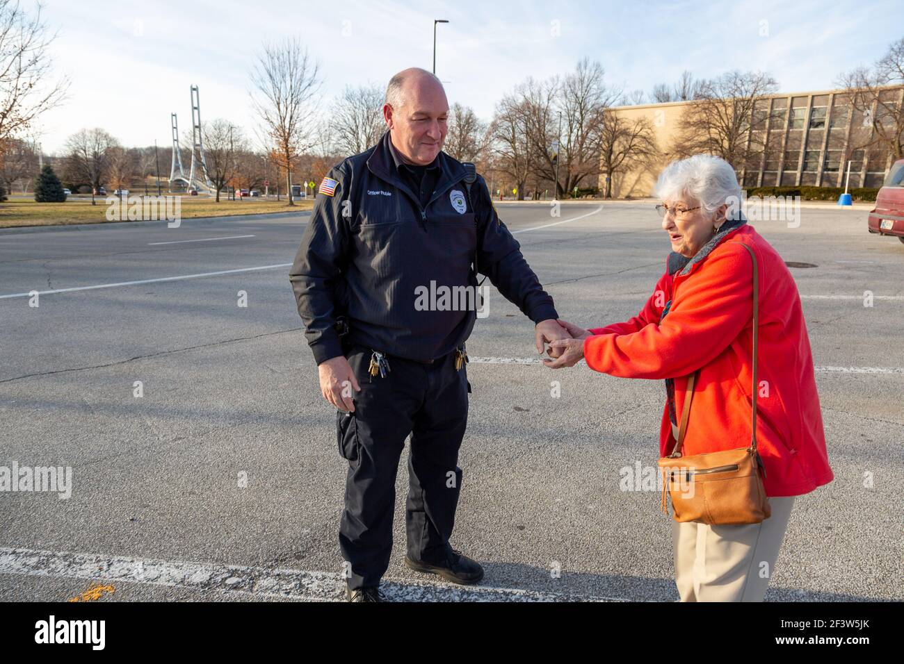 Ein Polizist unterstützt eine ältere Frau auf dem Campus Der Purdue University Fort Wayne Stockfoto