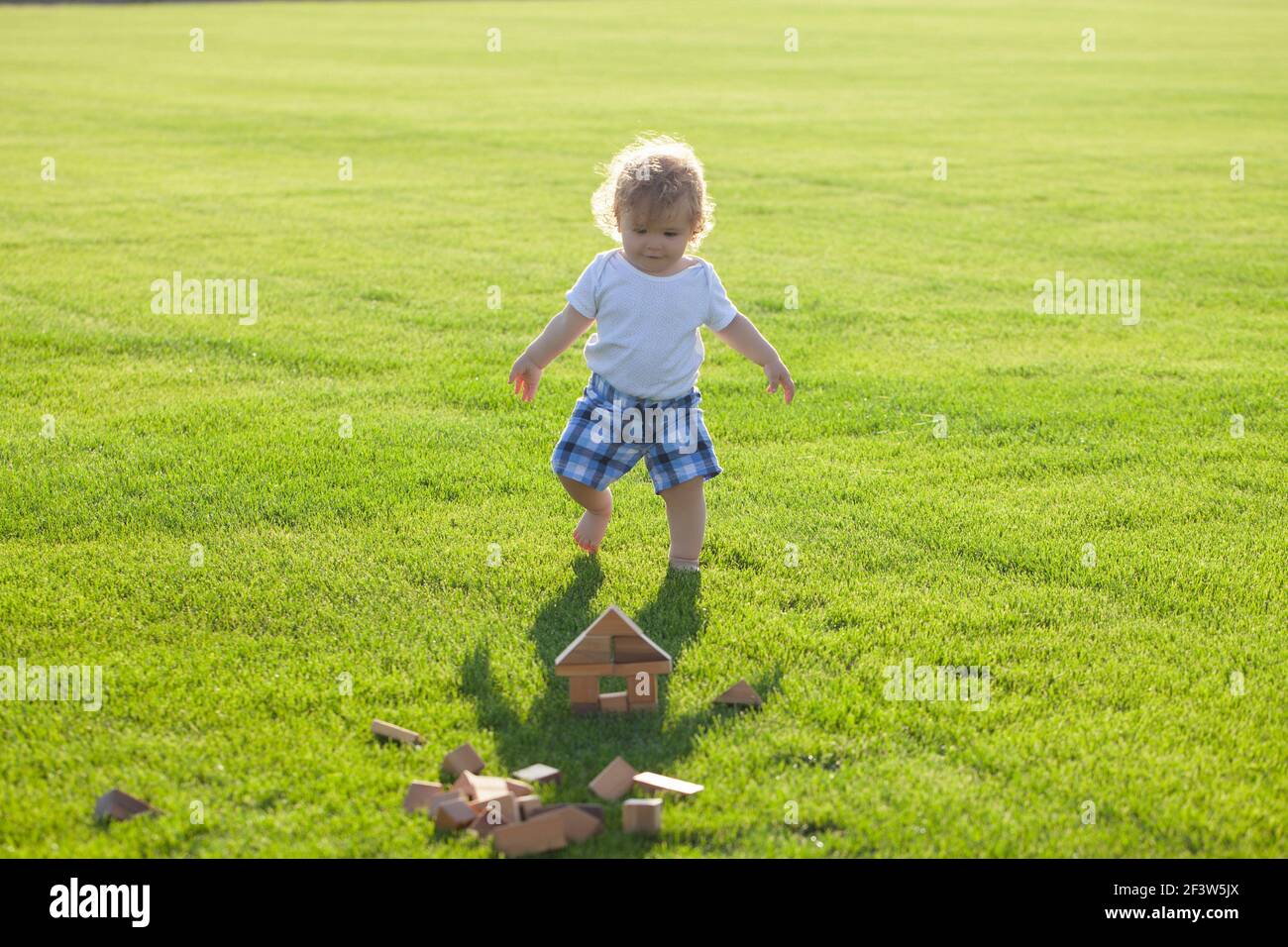 Versicherung Kinder. Baby spielen im grünen Gras. Entwicklung von Kindern. Stockfoto